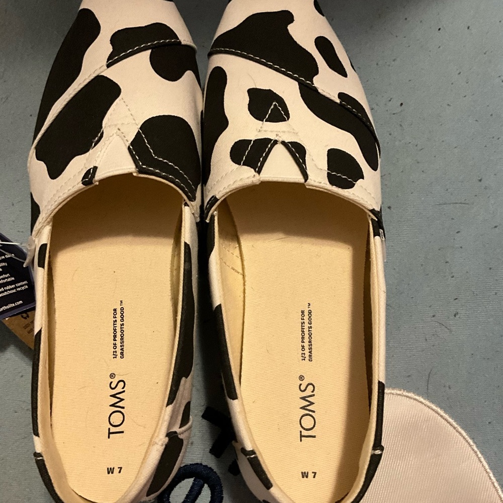 Toms Black and White Slip-On Loafers with Cow Print